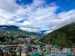 A Bhutanese village of whitewashed houses among terraced fields and forested hills