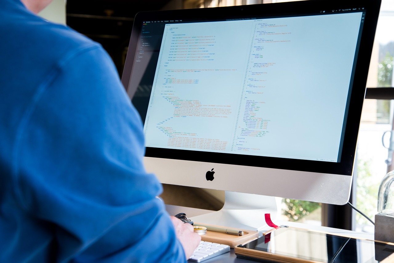 Programmer writing code on a large monitor