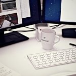 Programmer dual-monitor desk setup with keyboard