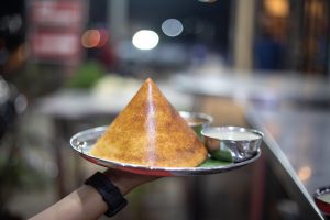 A crisp golden dosa served with chutney and sambar
