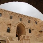 Deyrulzafaran Monastery exterior with golden limestone walls and domes