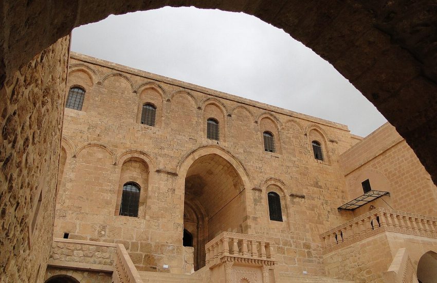 Deyrulzafaran Monastery exterior with golden limestone walls and domes