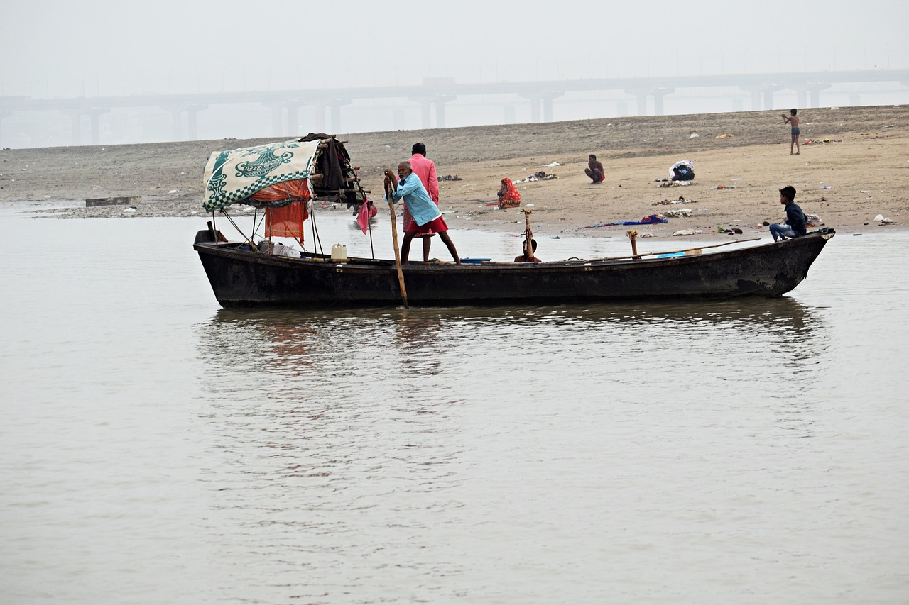 Pilgrims and boats on the sacred river Ganges at dawn