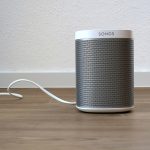 A modern wireless smart speaker on a shelf