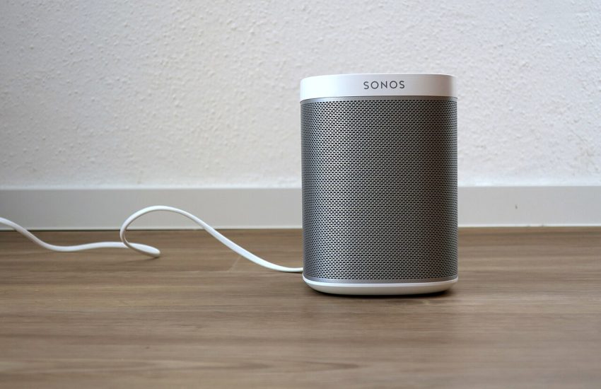 A modern wireless smart speaker on a shelf