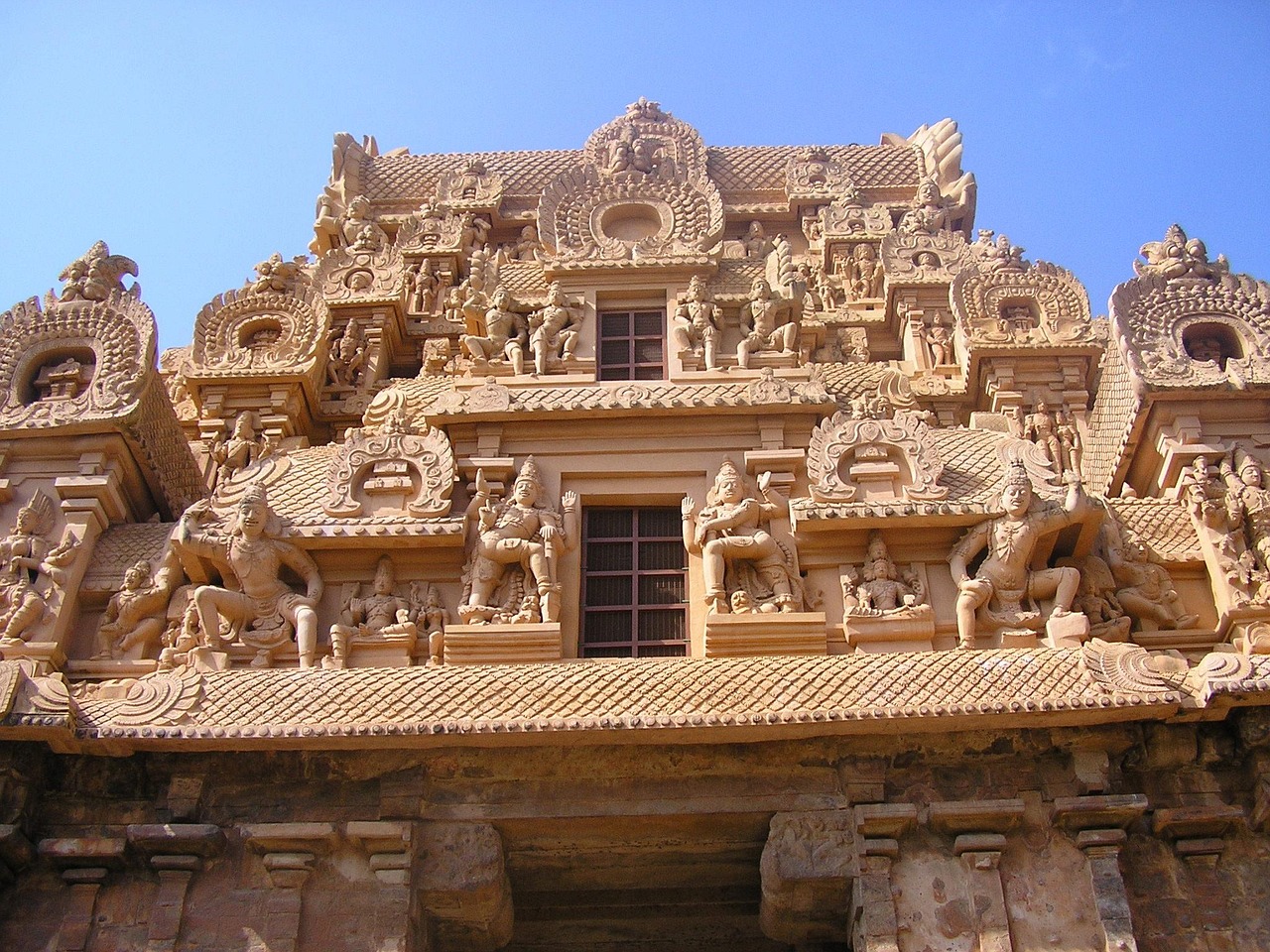 A towering South Indian temple gopuram covered in sculpted figures