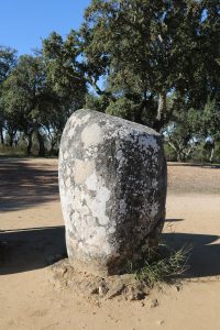 A single tall stone standing apart, worn smooth by millennia of weather