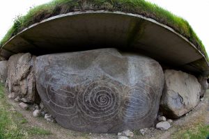 A kerbstone covered in swirling spirals and lozenges carved thousands of years ago