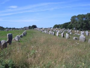 Weathered granite menhirs leaning under a wide Brittany sky