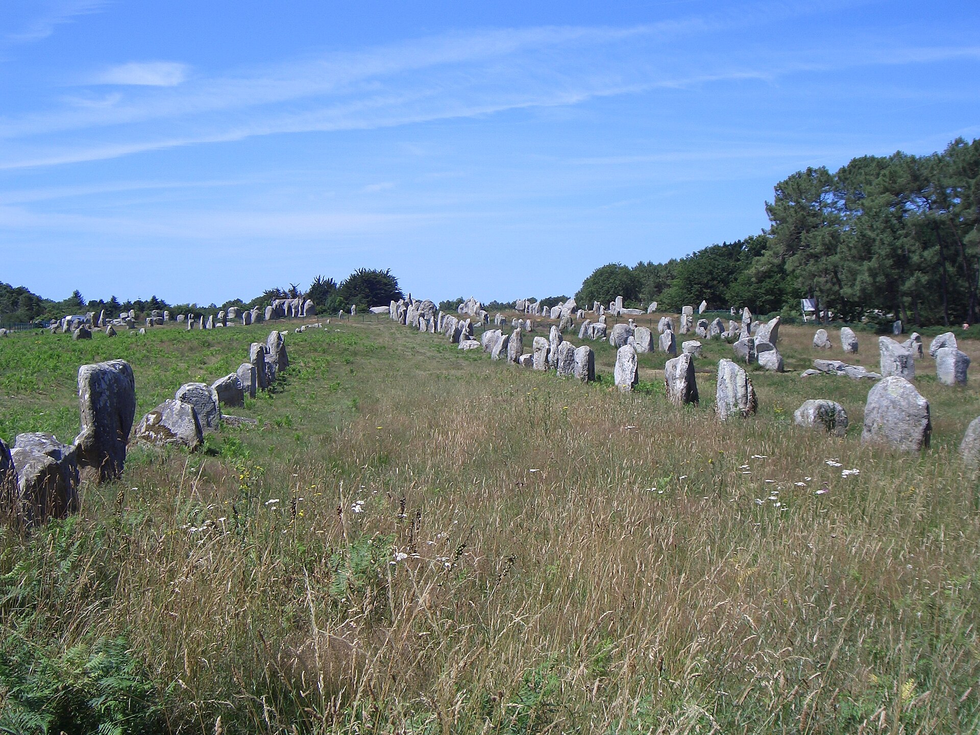 Weathered granite menhirs leaning under a wide Brittany sky