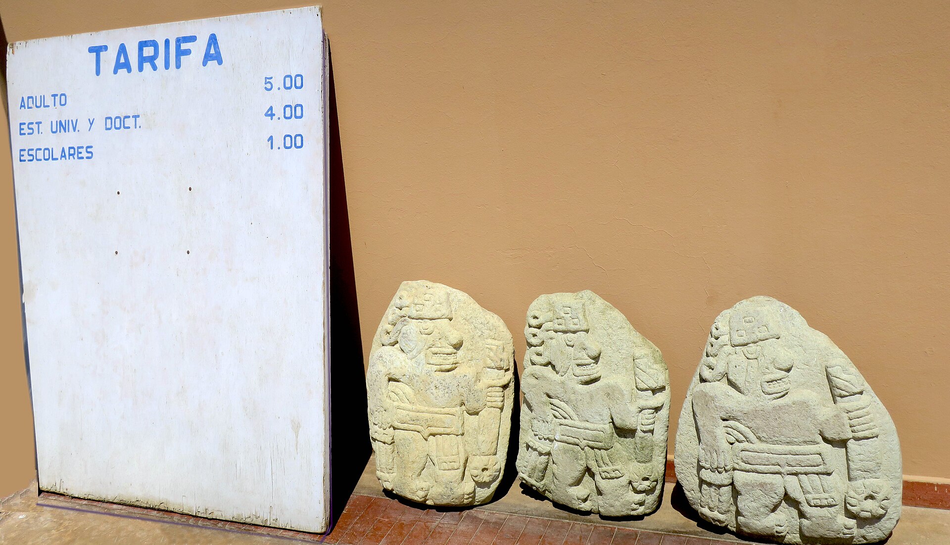 A stretch of the temple wall lined with carved monoliths, part of a frieze of hundreds of stones.