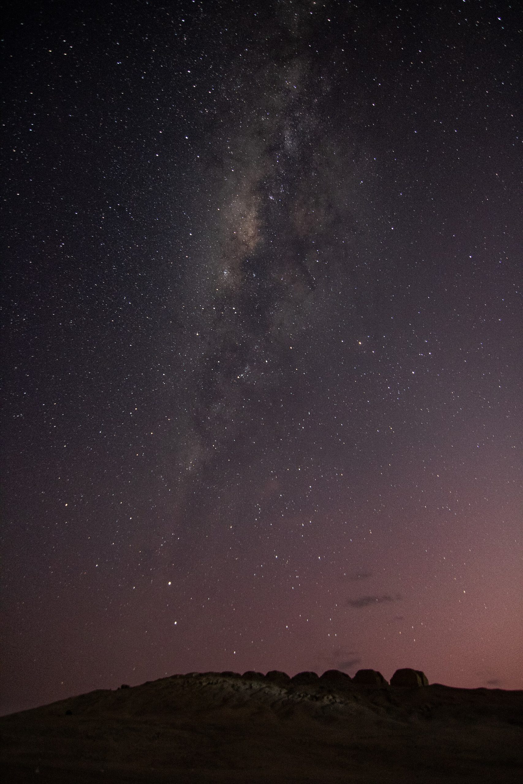 The Milky Way arching over the Thirteen Towers at night, above a site devoted to watching the sky.