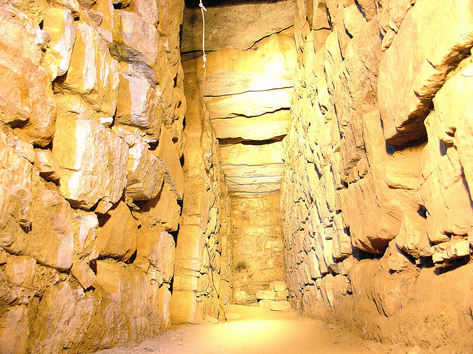 A narrow interior gallery inside the temple. These stone-lined passages form a dark labyrinth through the platforms.