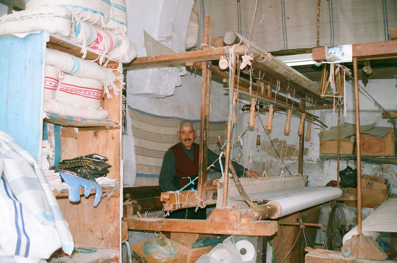 A weaver working at a wooden loom
