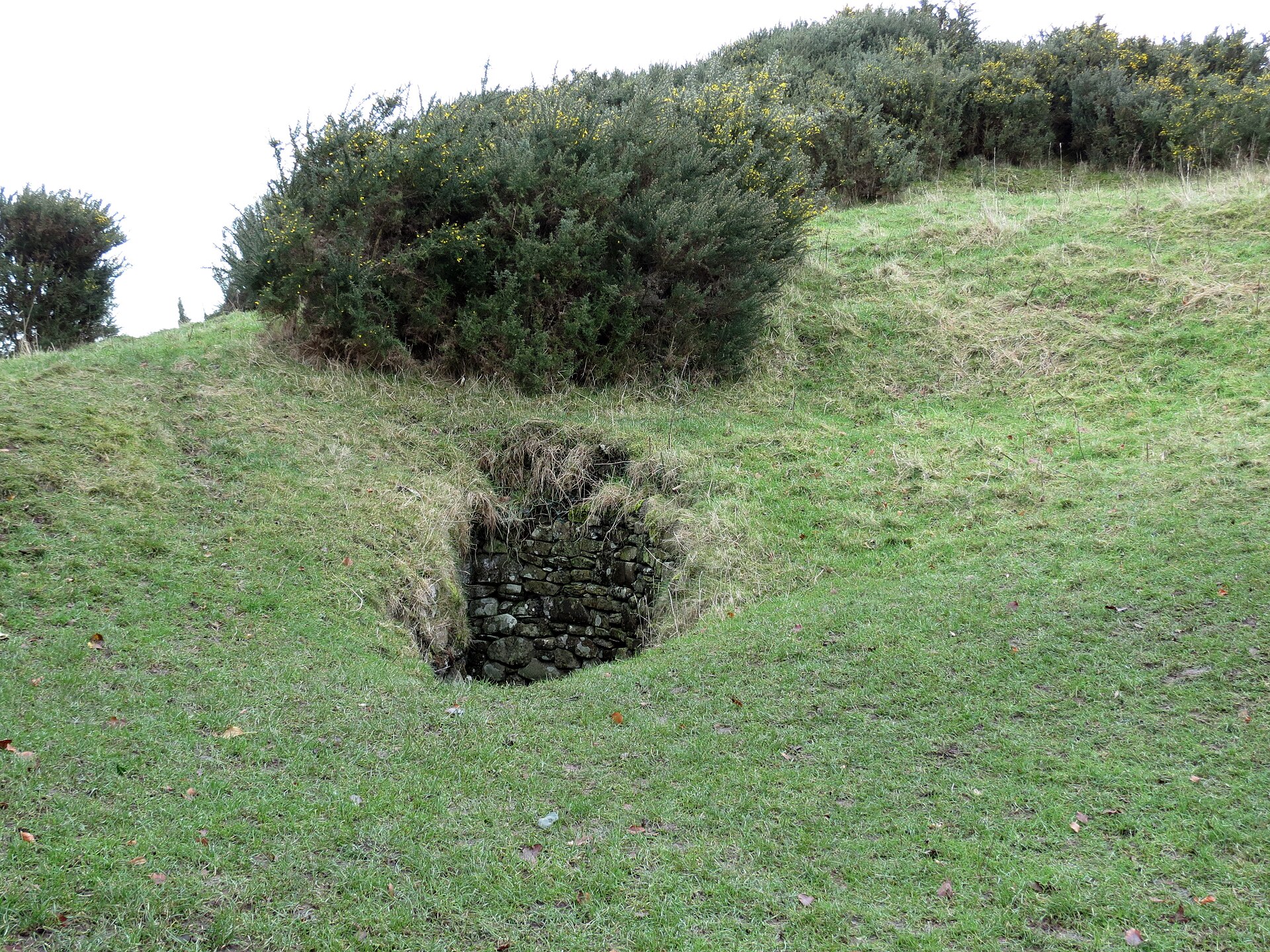 The broad flank of the cairn, layered with turf and stone