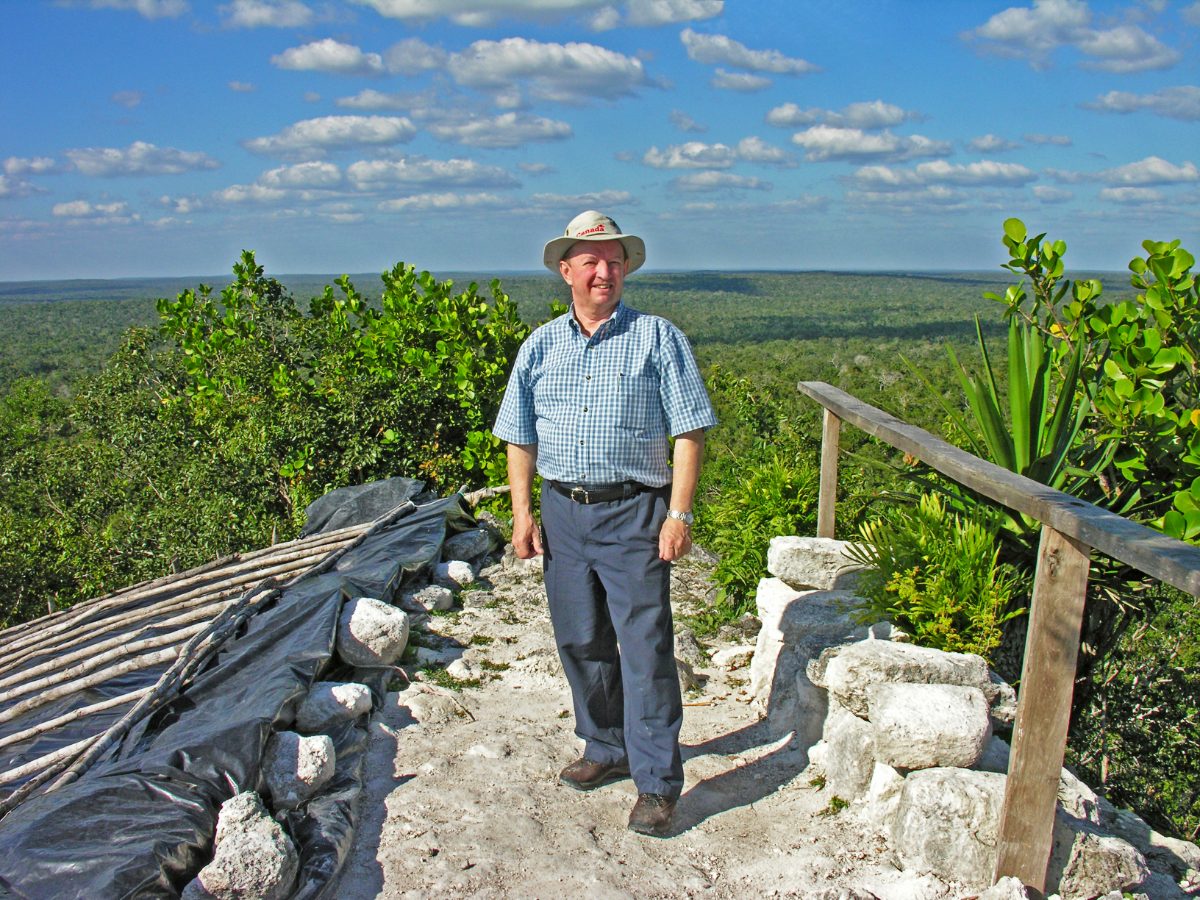 A visitor standing atop La Danta showing the scale of the pyramid against the surrounding jungle