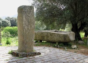 A carved statue-menhir with the faint outline of a sword and dagger
