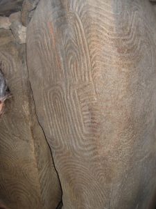 Close view of an engraved slab covered with swirling motifs at Gavrinis