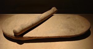 A saddle-shaped millstone and roller used for grinding grain in early China