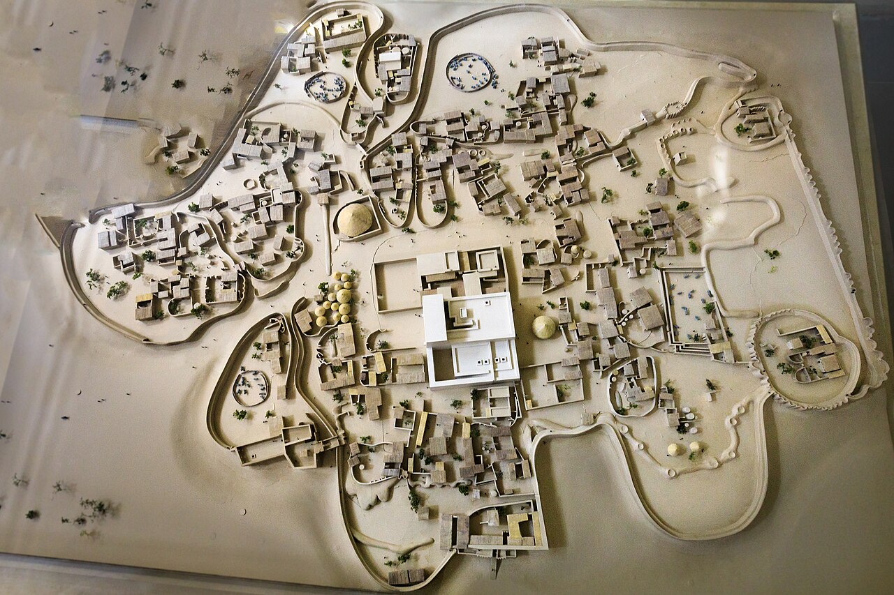 In the middle the Deffufa, religious power centre; above left the circular “hut” (14 m diameter) that must have served a