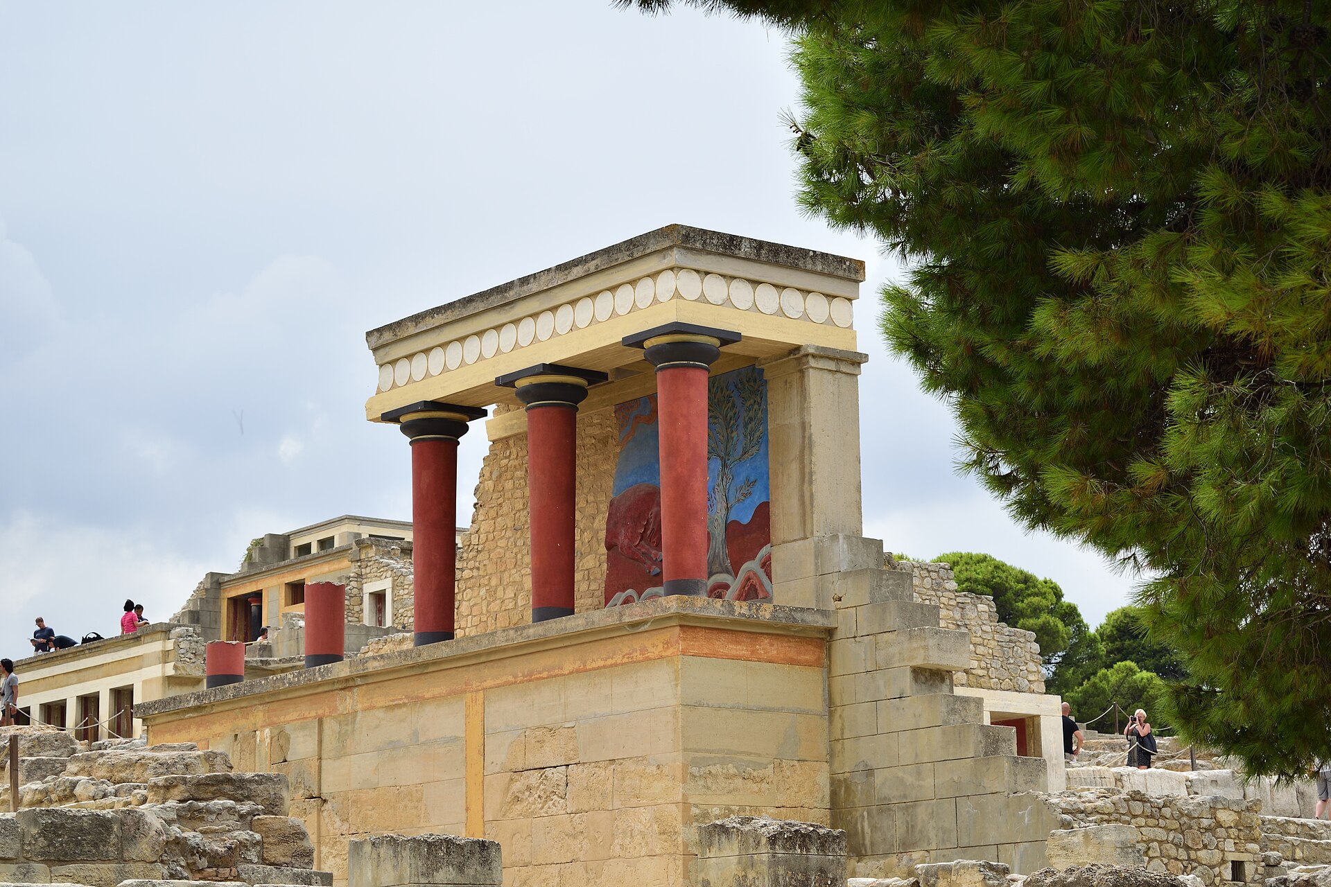 The reconstructed north entrance of the Palace of Knossos, with its distinctive red columns and a charging bull fresco — the image most people picture when they think of Minoan Crete.
