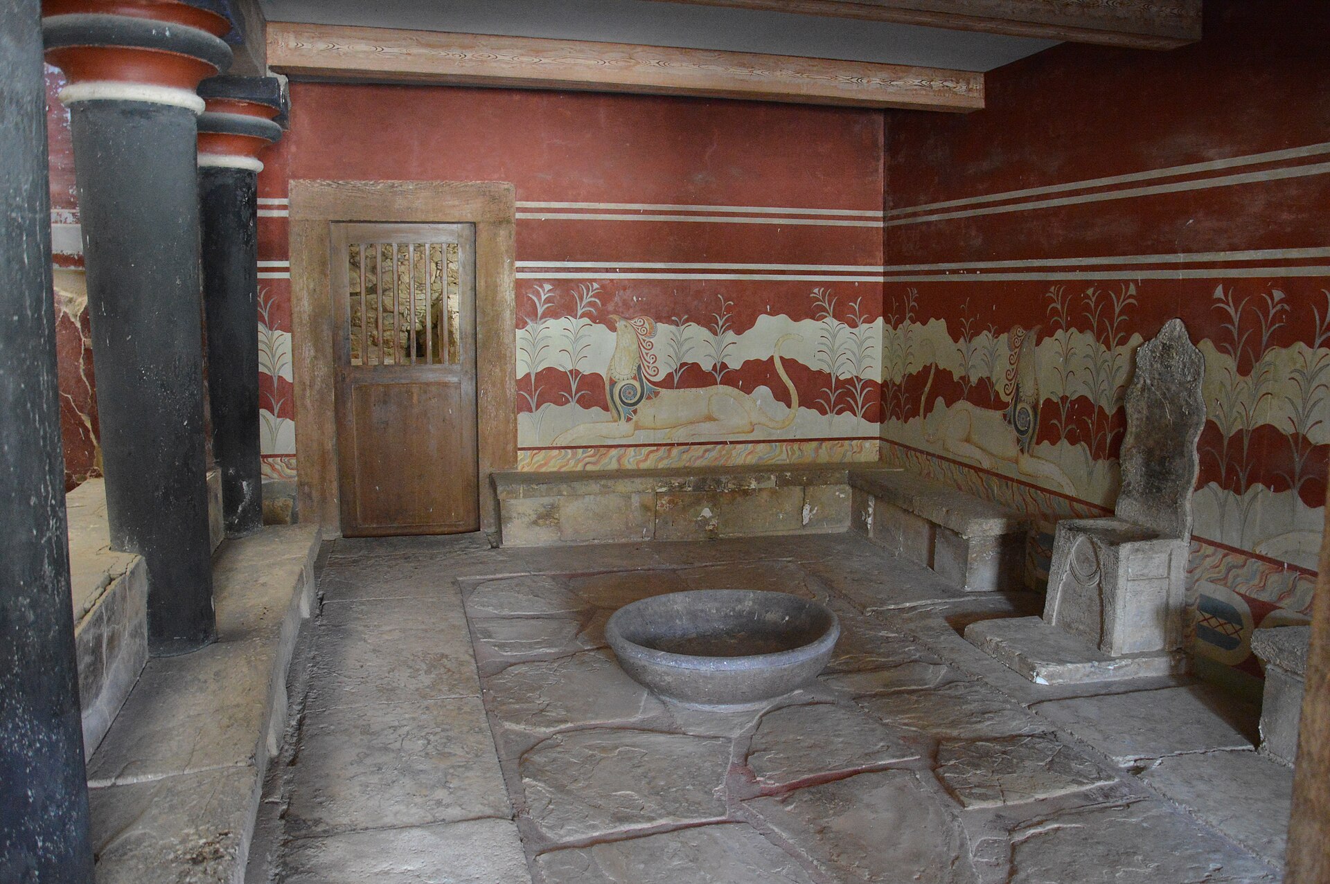 The throne room of Knossos, where a simple stone seat — often called Europe’s oldest throne — sits guarded by painted griffins.