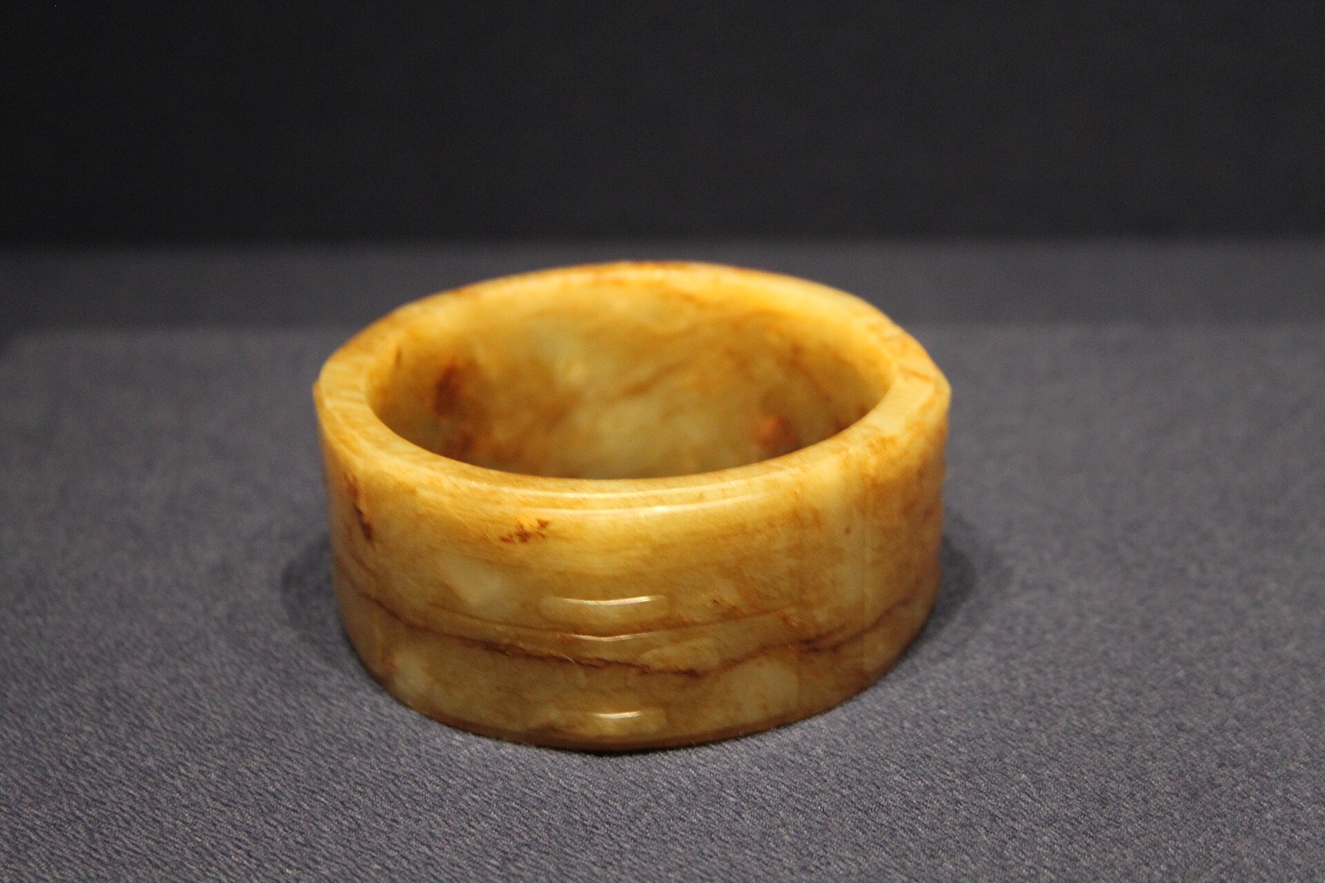 A jade cong from the Liangzhu culture, its square outer form enclosing a circular bore, carved from stone harder than steel tools of the age.