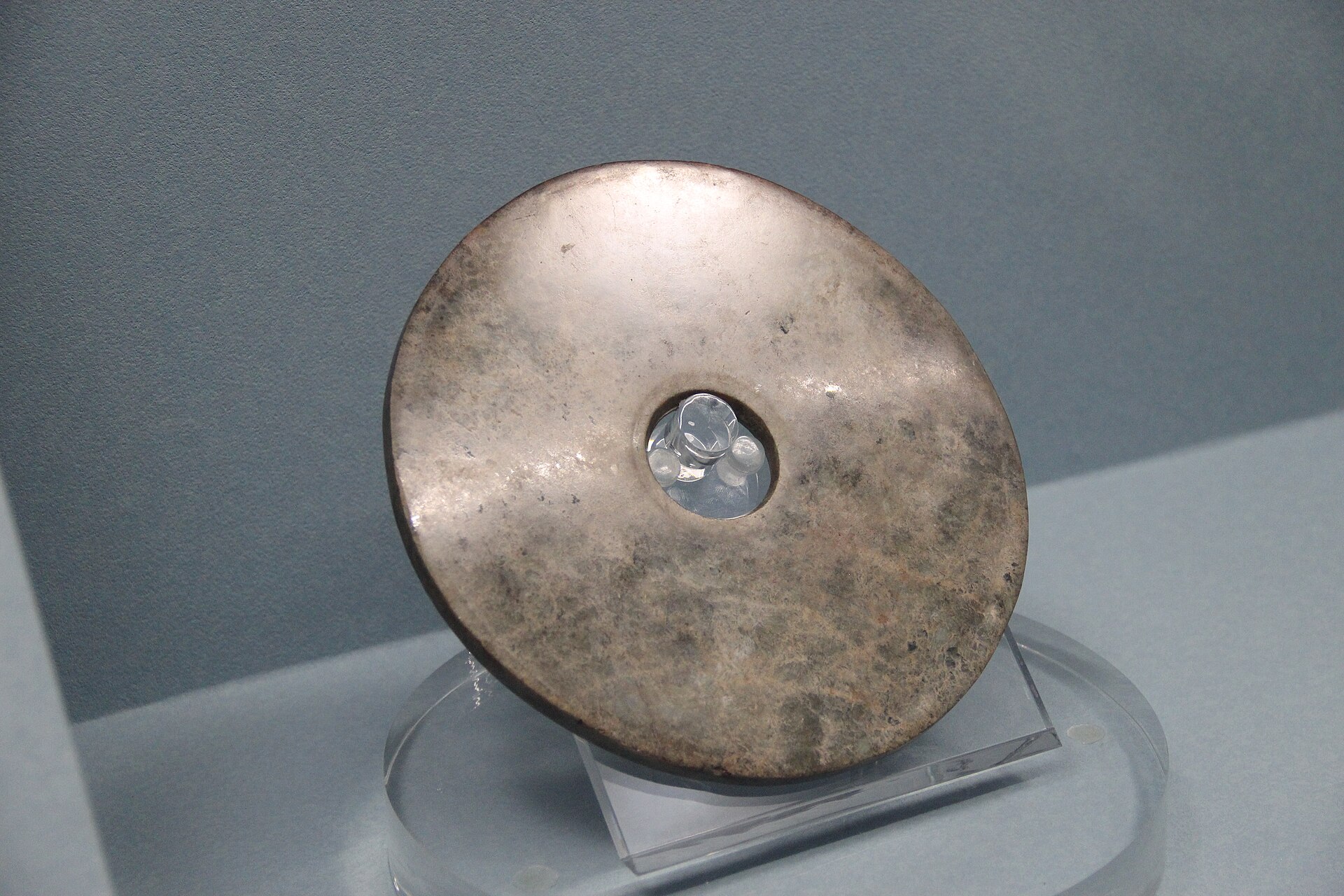 A polished jade bi disc from the Liangzhu culture, one of the smooth ring-shaped objects buried in great numbers with the dead.