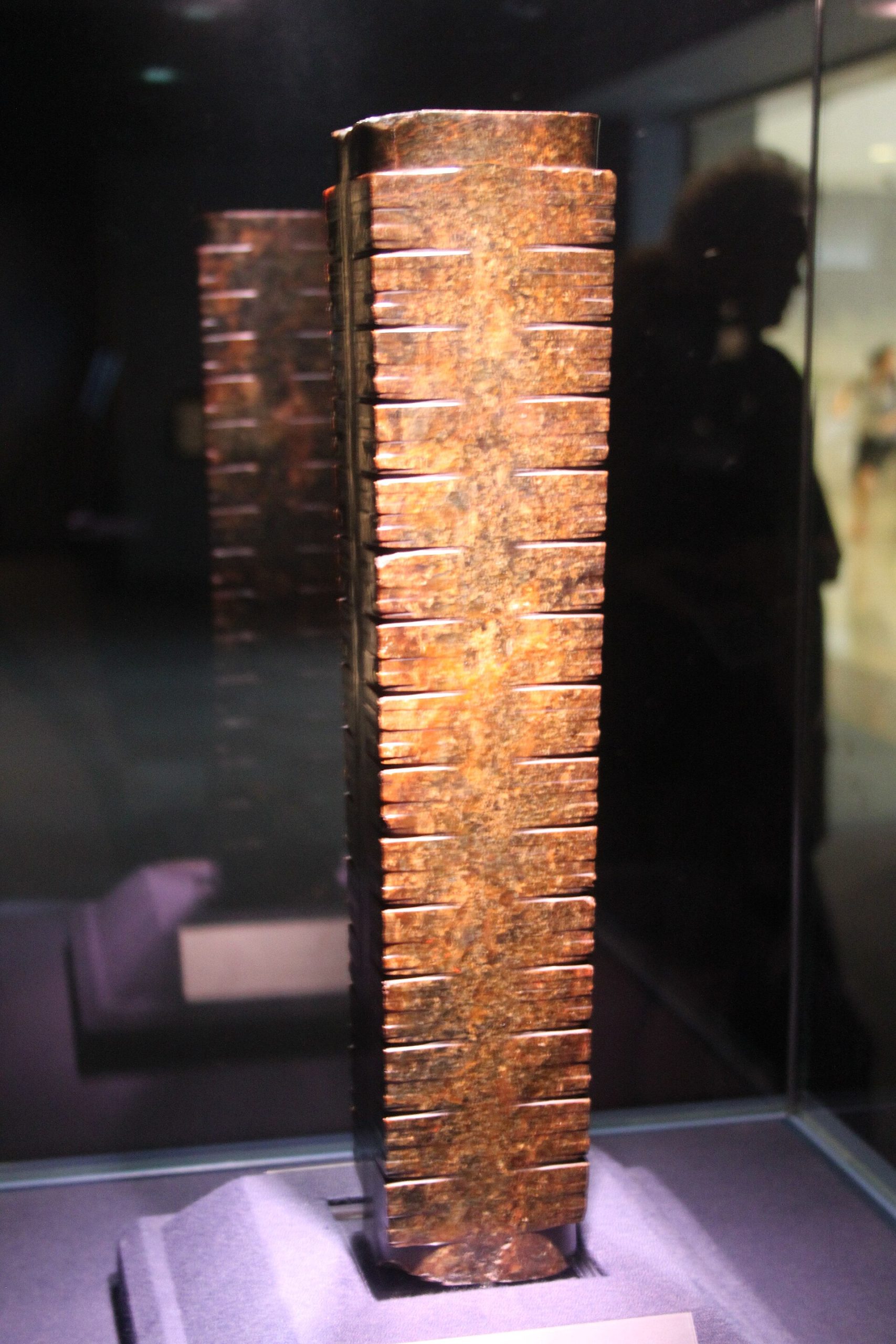 A jade cong from Liangzhu, its worn surface still carrying the mysterious carved face the culture returned to again and again.