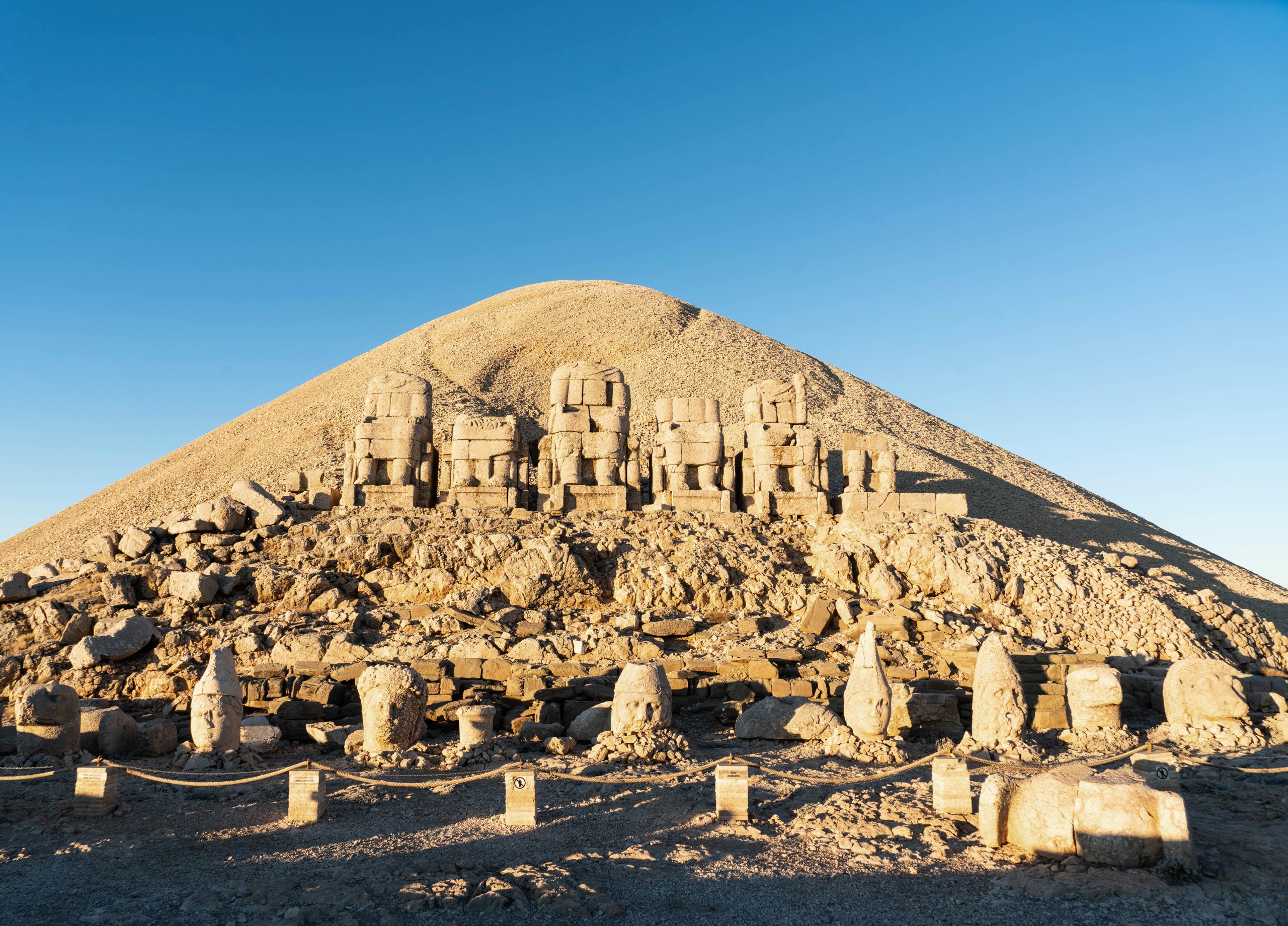 Sunrise over the standing stones and heads of Mount Nemrut