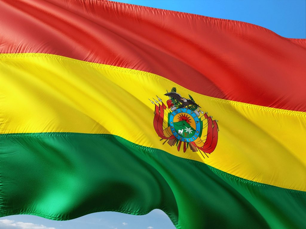 A checkered banner echoing the wiphala, symbol of Andean identity