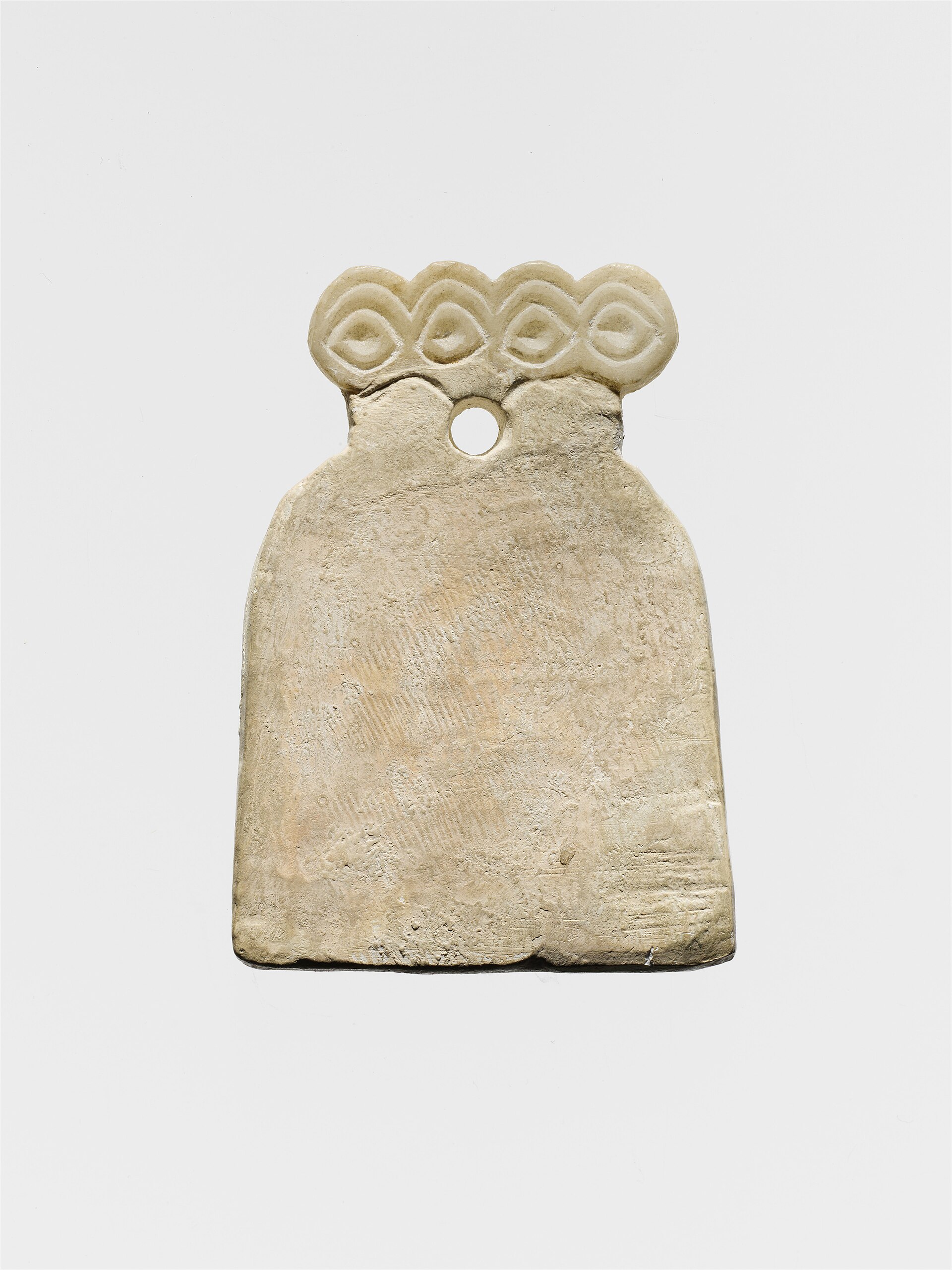 A single alabaster eye idol, its oversized eyes conveying a sense of rapt, unblinking attention.