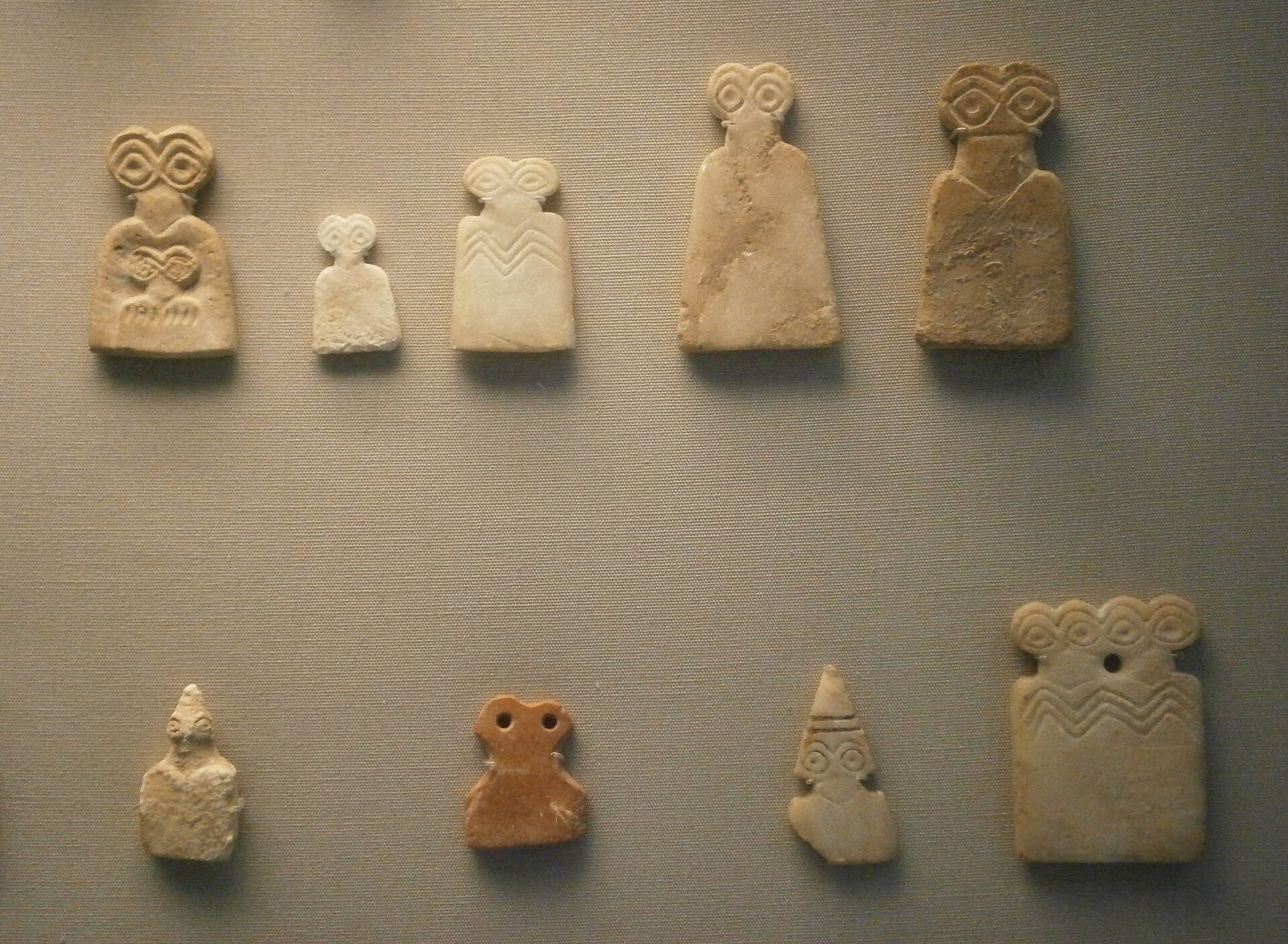 A group of the celebrated eye idols of Tell Brak, each dominated by a pair of wide, staring eyes.