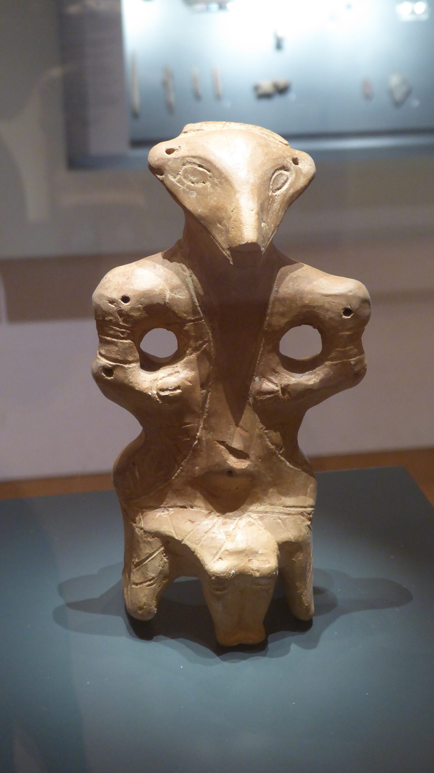 A seated clay figurine from Vinča-Belo Brdo, its face rendered in the culture’s distinctive mask-like style