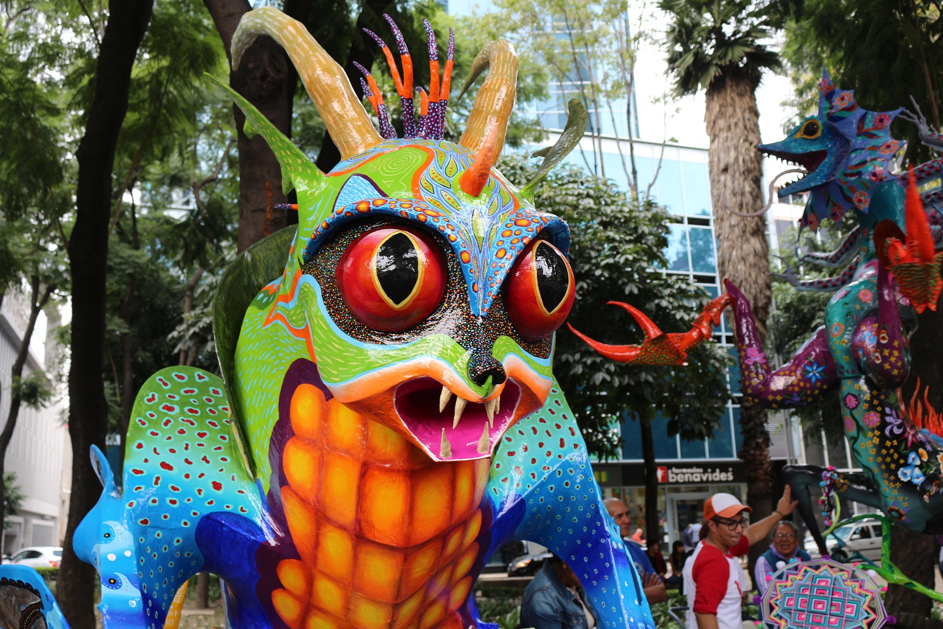 Giant alebrije figures parade through the streets during Oaxaca's festival season
