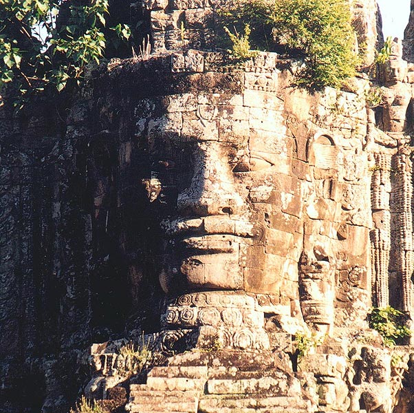 A monumental face-tower gate leading into the walled city of Angkor Thom.