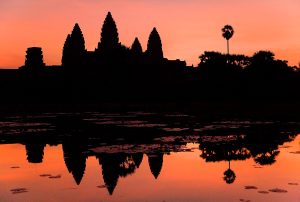 Angkor Wat reflected in its moat at dawn, the largest religious monument in the world.