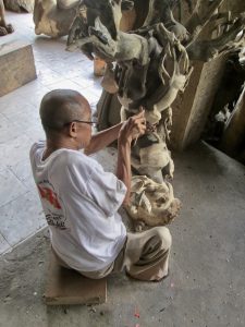 A Balinese artisan carving wood