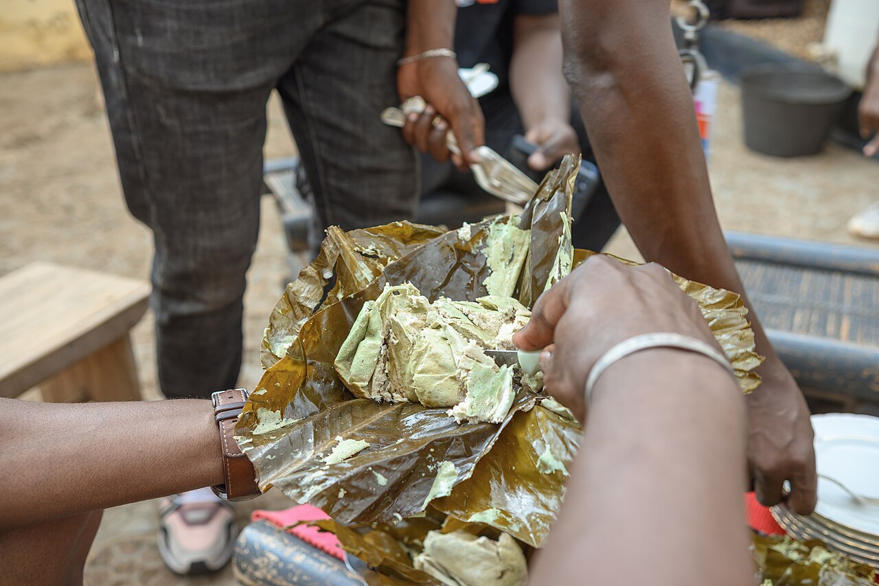 Sharing a pistachio-seed dish at a Cameroonian gathering.
