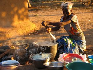 A woman making nshima, the staple porridge of Zambia.