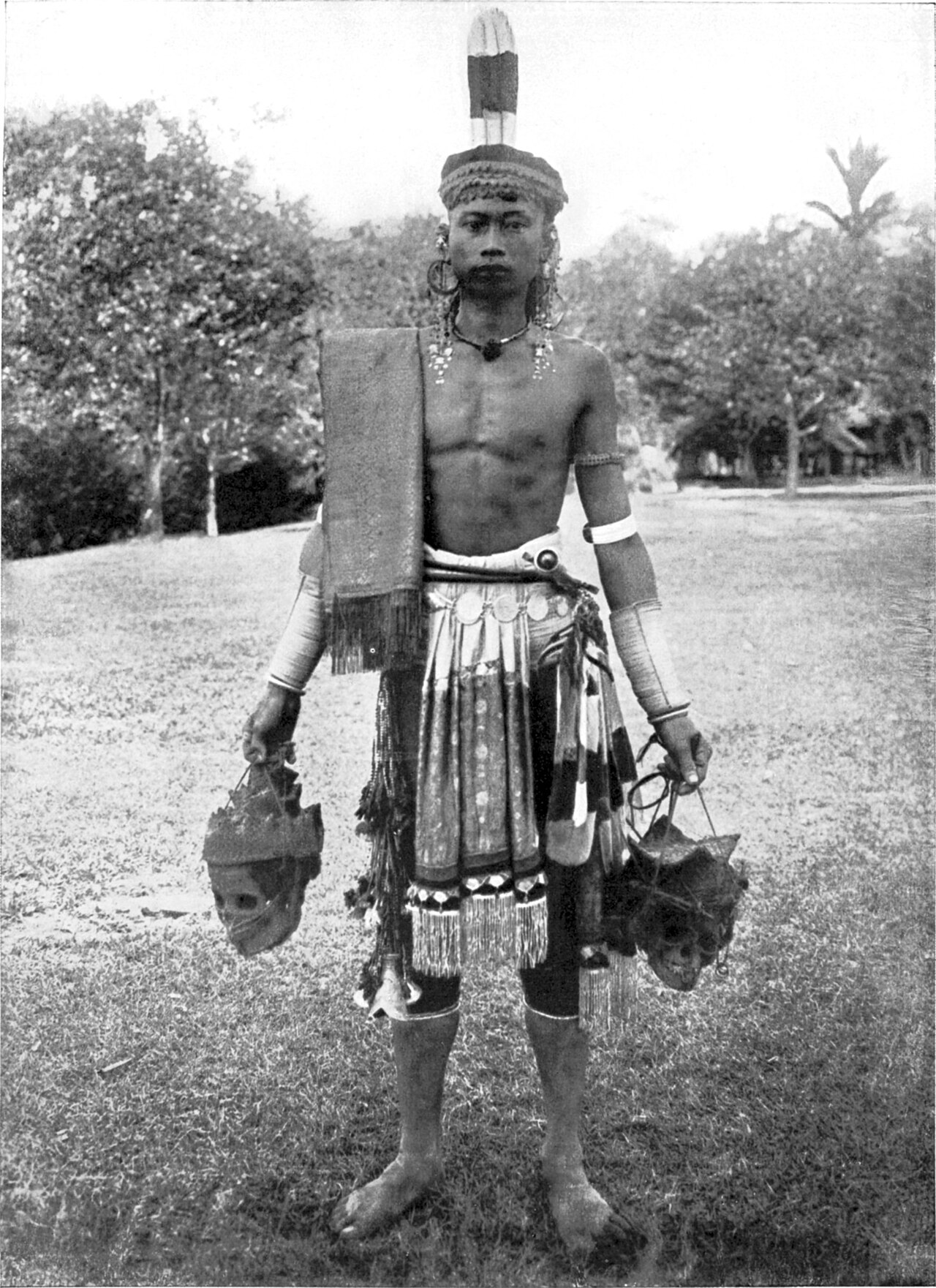 A Dayak in traditional warrior dress, from an old photograph