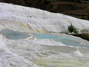 The ruins of Hierapolis spread above the white slopes of Pamukkale.