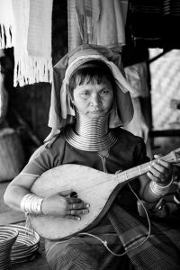 A Karen woman playing a traditional stringed instrument