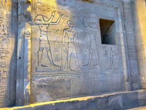 Carved reliefs of the king and gods on the walls of Kom Ombo.