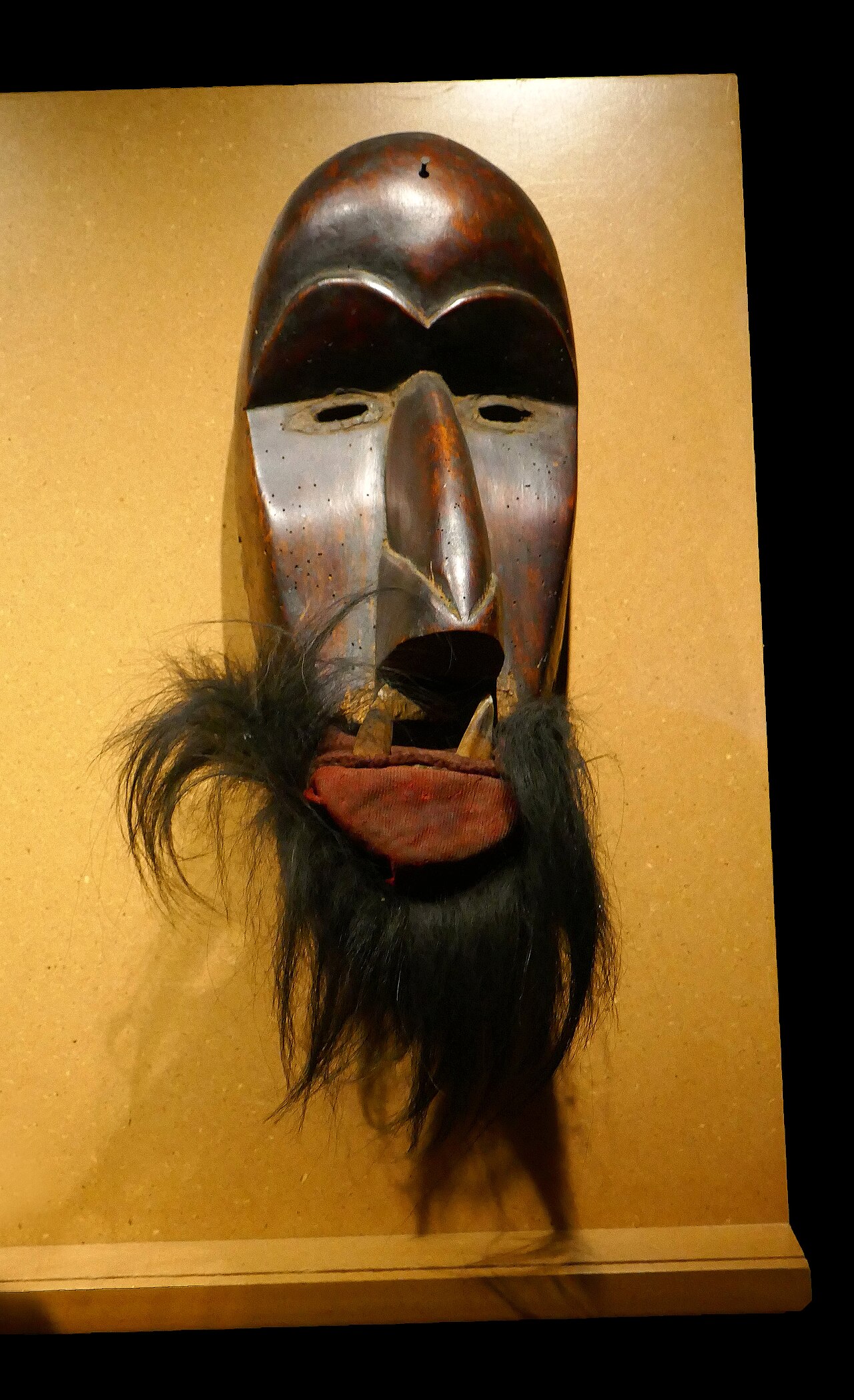 A masked spirit dancer of the Guerze, at a festival in the forest.