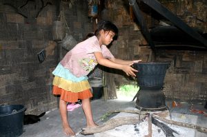 A Lao girl steaming the sticky rice that is the staple of the country