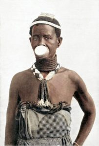 An older Makonde woman in festive adornment; the people speak Chimakonde.