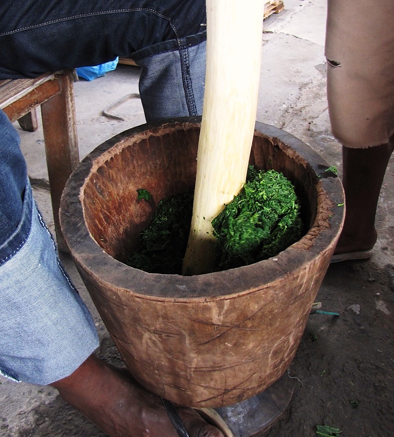 Cassava leaves pounded in a mortar, a staple relish of Sierra Leone.