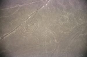 The monkey geoglyph, its tail curled in a spiral, among the great animal figures of Nazca