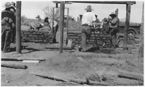 O'odham workers building an adobe structure in the Arizona desert.